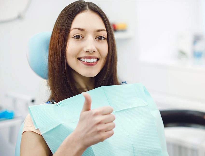 Patient smiling at her nearby dentistry